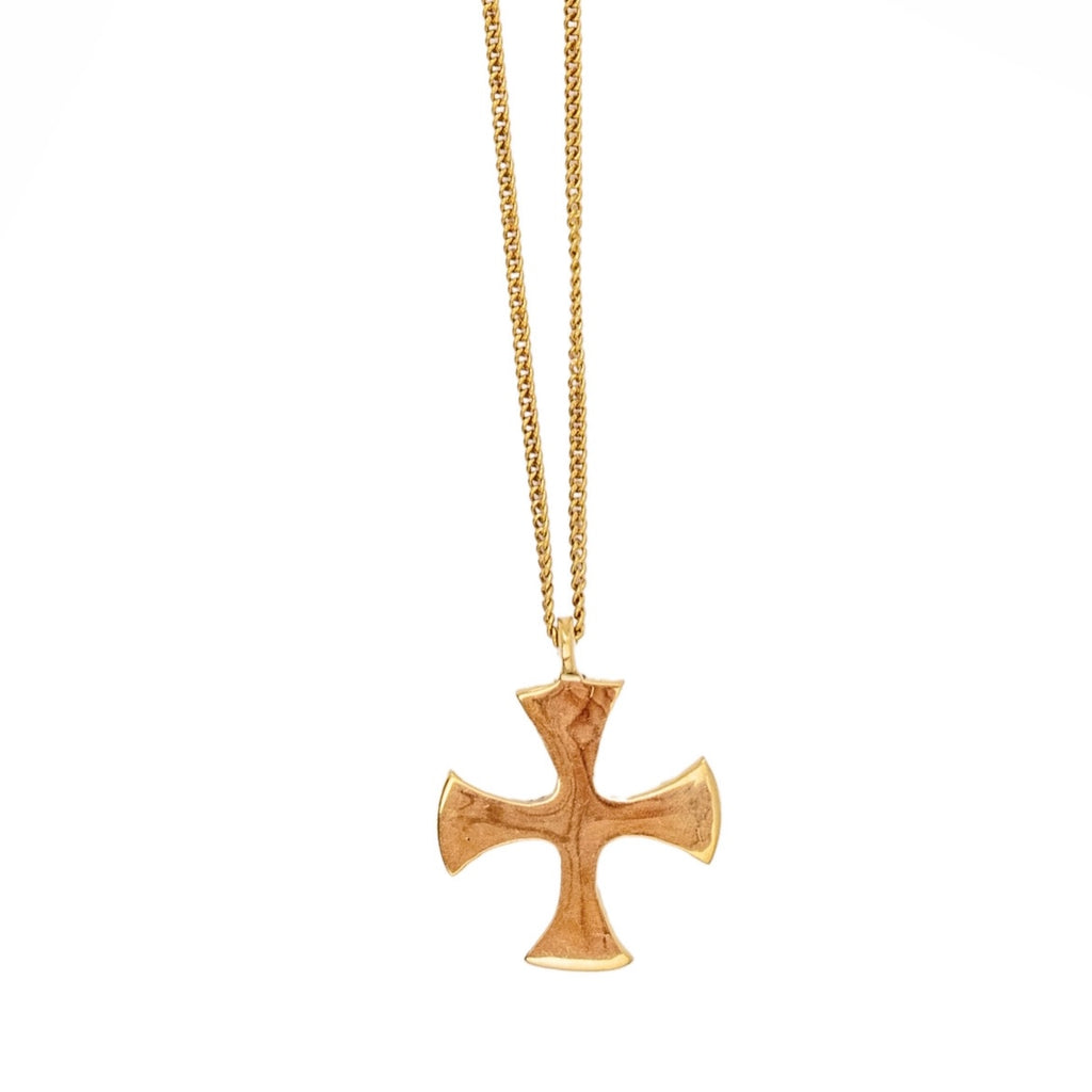 A gold-colored brass cross pendant necklace on a chain, displayed against a white background.